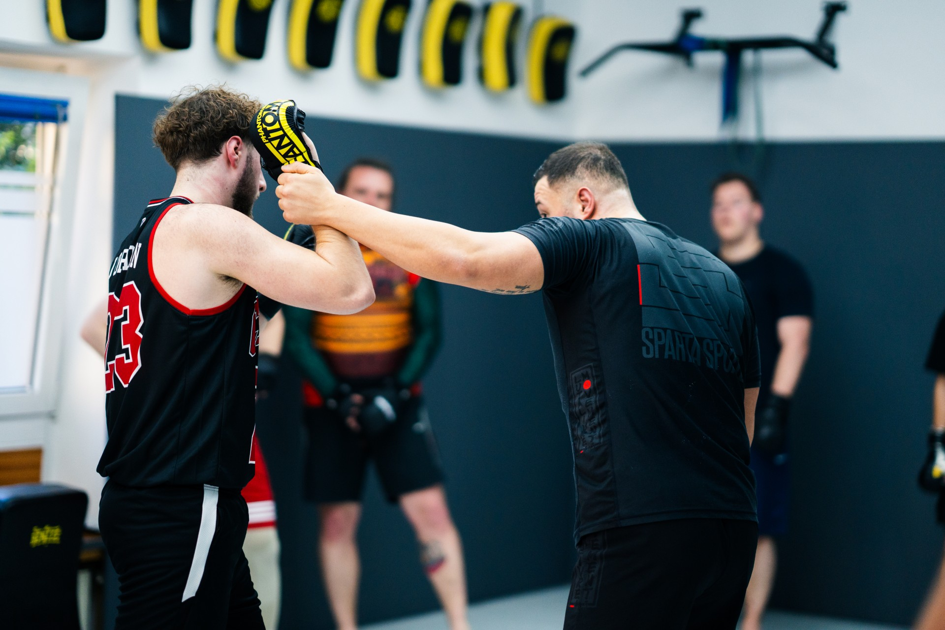 Muay Thai Trainerin demonstriert kraftvollen Kick mit dem Schienbein im Dojo
