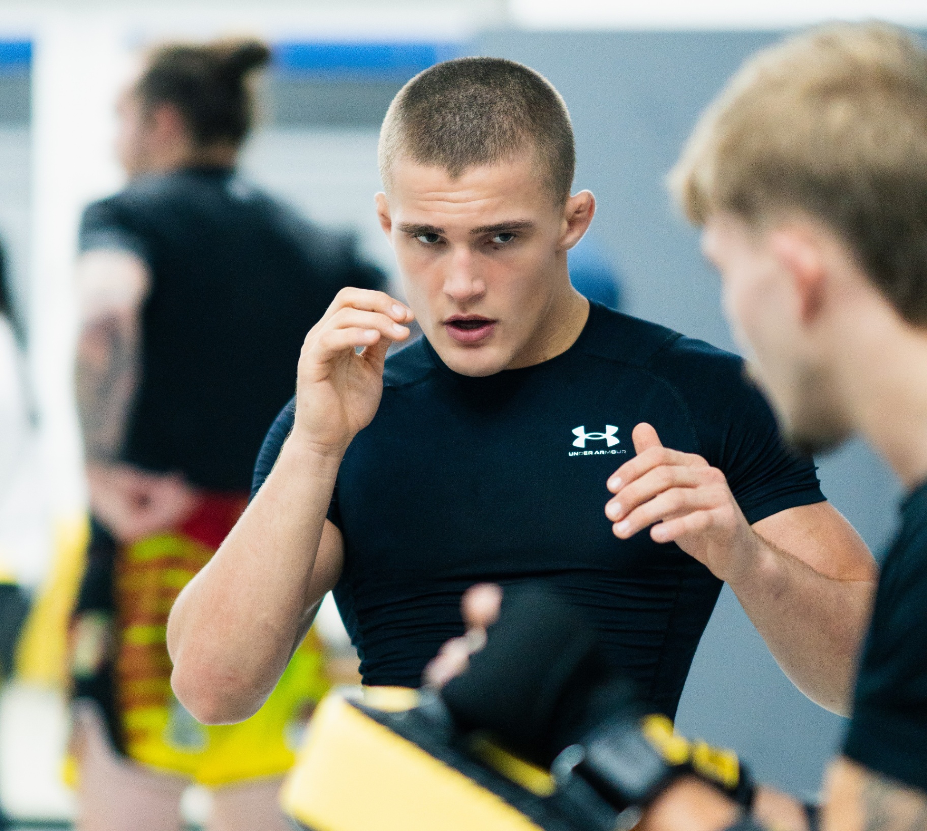 Kickboxerin trainiert hohen Roundhouse-Kick gegen einen Sandsack im Gym