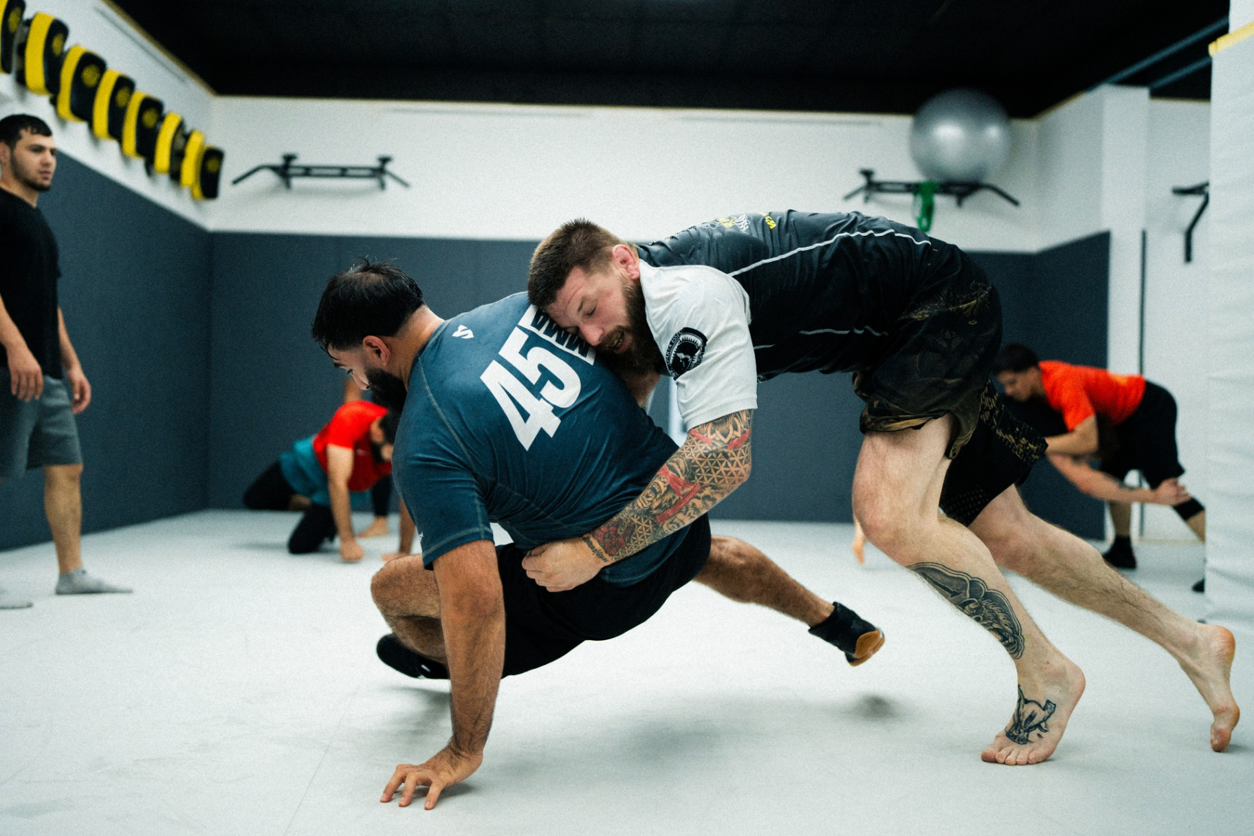 Ringer-Duell mit Takedown-Versuch auf der Trainingsmatte bei 45 MMA